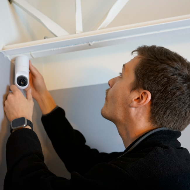 Technician hanging a security camera